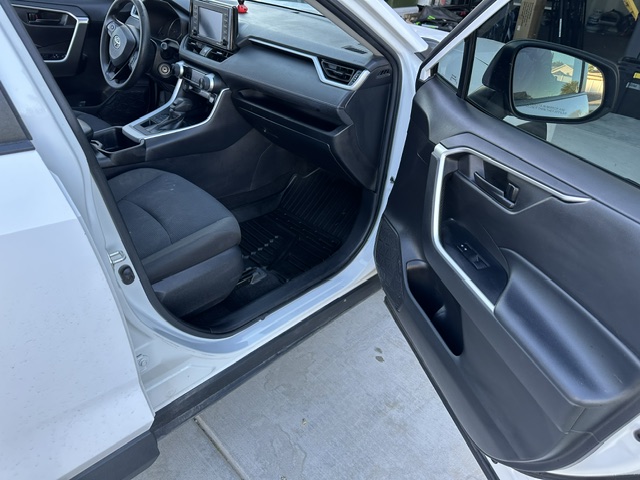 After interior detailing: clean driver door panel, seat and floor mat in a white Toyota RAV4