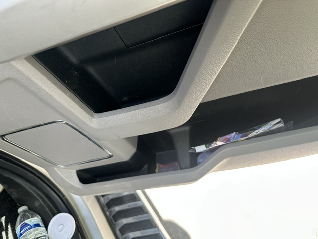 Before interior detailing: door pocket with trash and dust in a Ford F-150 Lariat