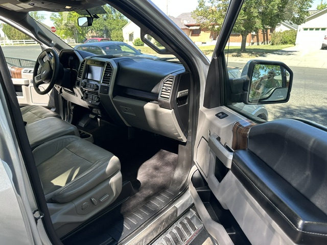 After interior detailing: clean driver side leather seat, dash, and floor carpet in a Ford F-150 Lariat